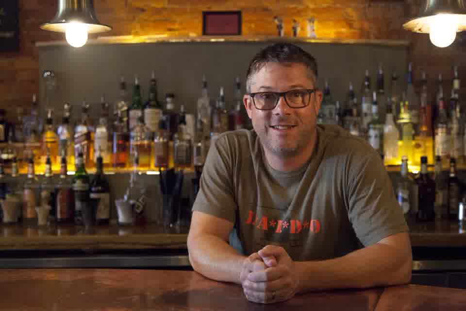 Jason Adelman leaning on the bar at The Feve