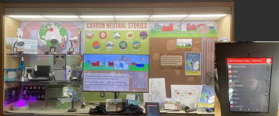 The finished exhibit case, with a kiosk menu of the nine Carbon Neutral Stories