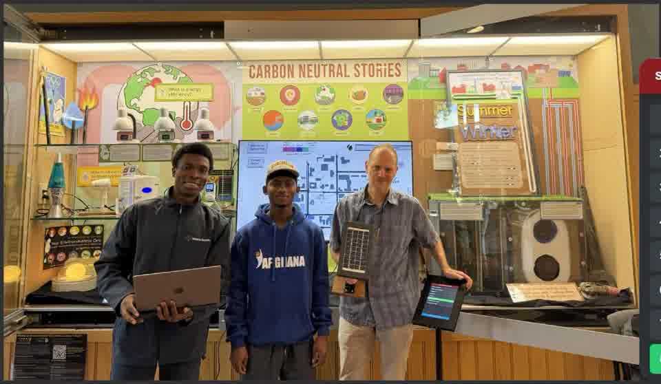 Three people at the Carbon Neutral Stories exhibit in Oberlin College's Science Center