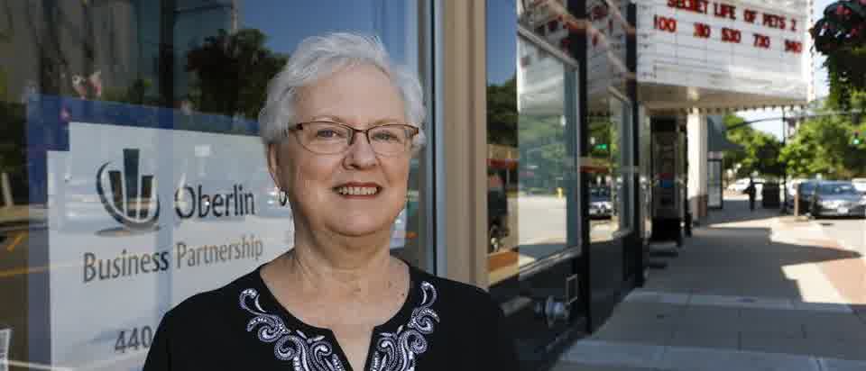 Janet Haar outside the Oberlin Business Partnership, with Main Street behind her
